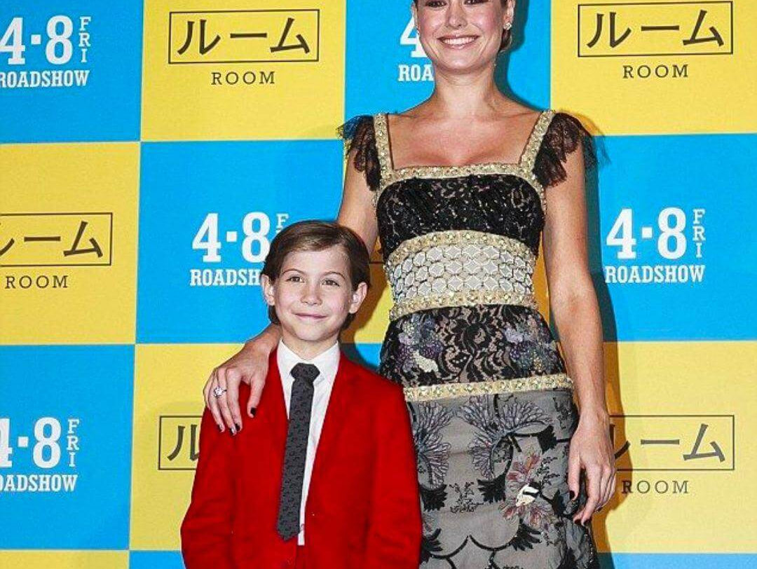 Jacob Tremblay in a sharp red suit poses with Brie Larson at the 'Room' Tokyo Premiere, showcasing stylish kids' fashion.