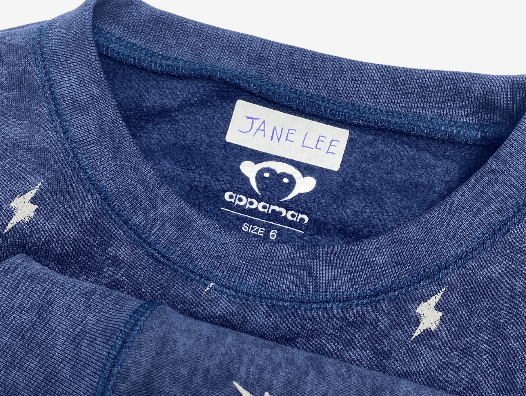 Close-up of an Appaman kids' shirt with a label reading 'Jane Lee'—stylish and ready for adventure!