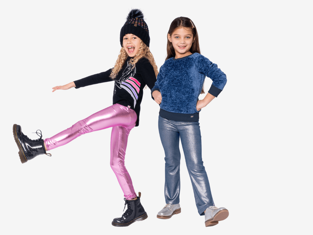 Two trendy girls showcase stylish outfits: one in shiny pink leggings and boots, the other in cozy blue top and jeans.