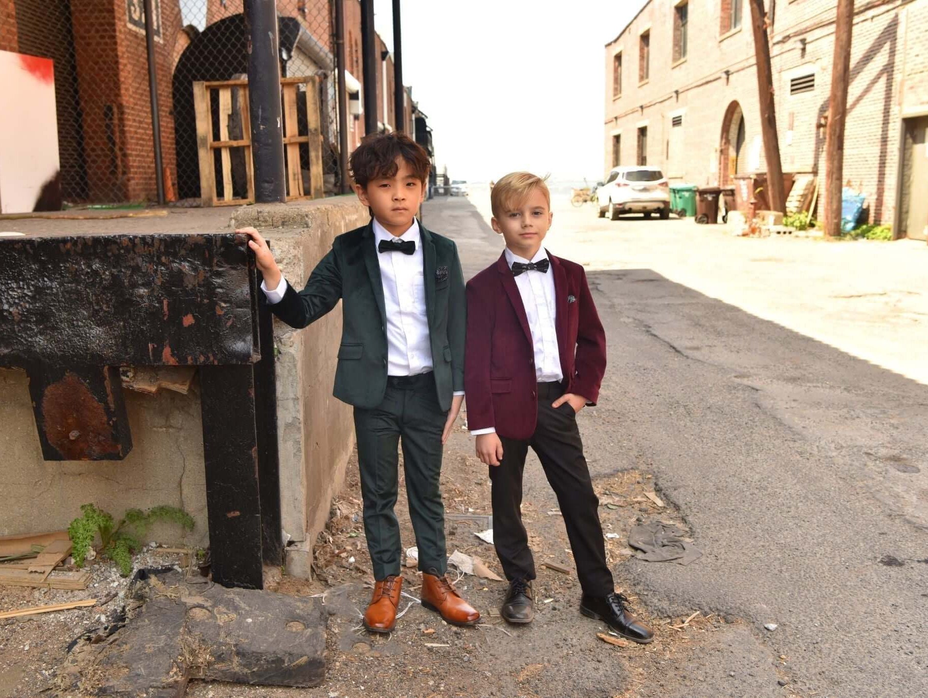 Two stylish boys in chic suits pose confidently in an urban setting, showcasing Appaman's trendy dance outfits.