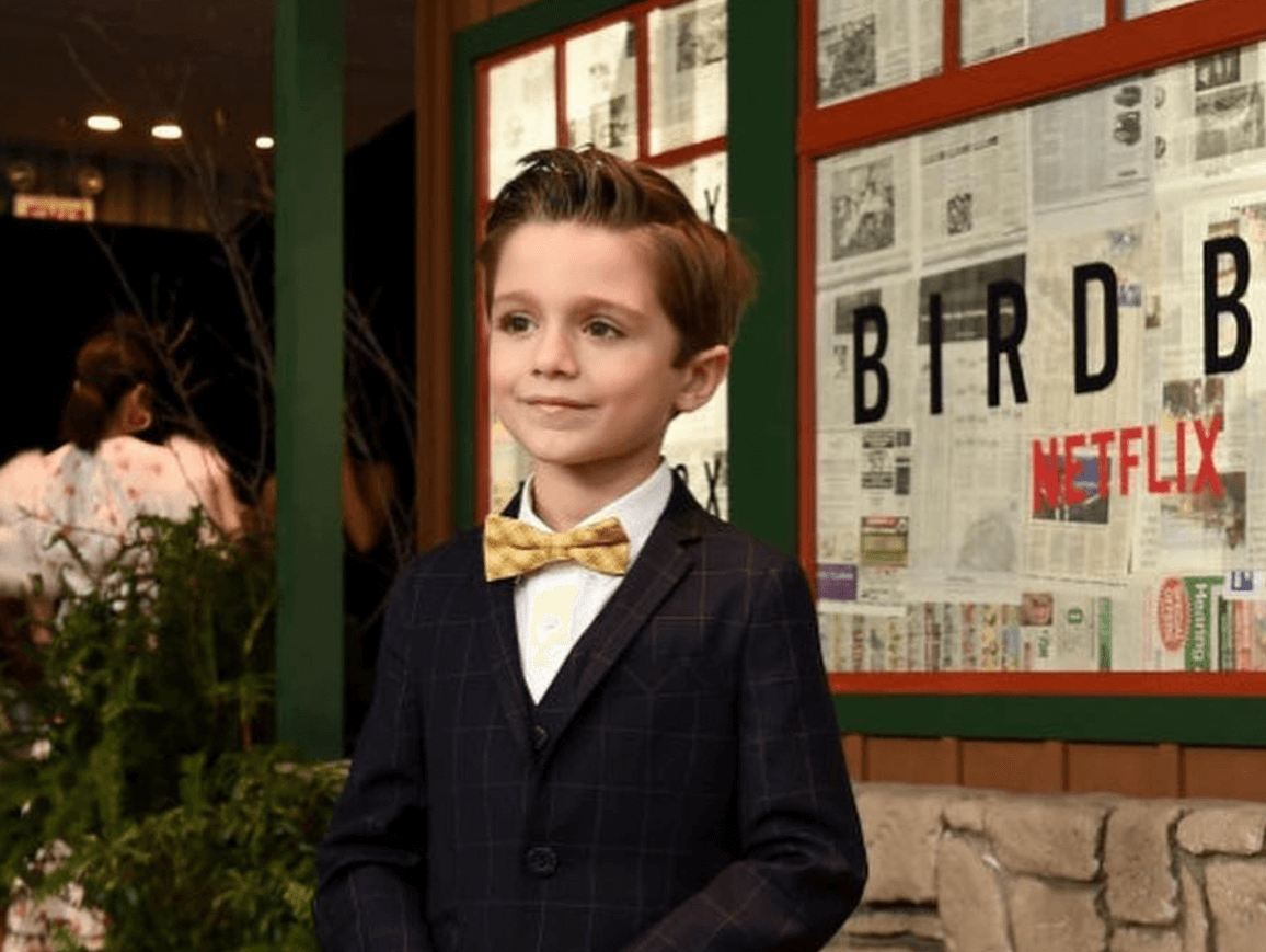 Julian Edwards flaunts stylish kids fashion at the Bird Box premiere, showcasing modern boys' suit and playful bowtie.