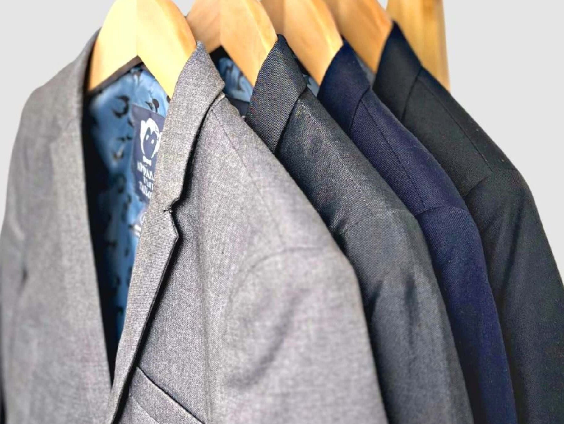 Stylish collection of Appaman boys suits hanging on wooden hangers, showcasing fine tailoring and modern designs.