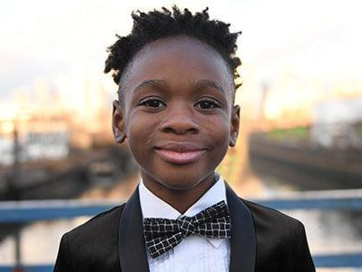 Stylishly dressed boy in a tuxedo with bowtie, ready for festive celebrations and special occasions.