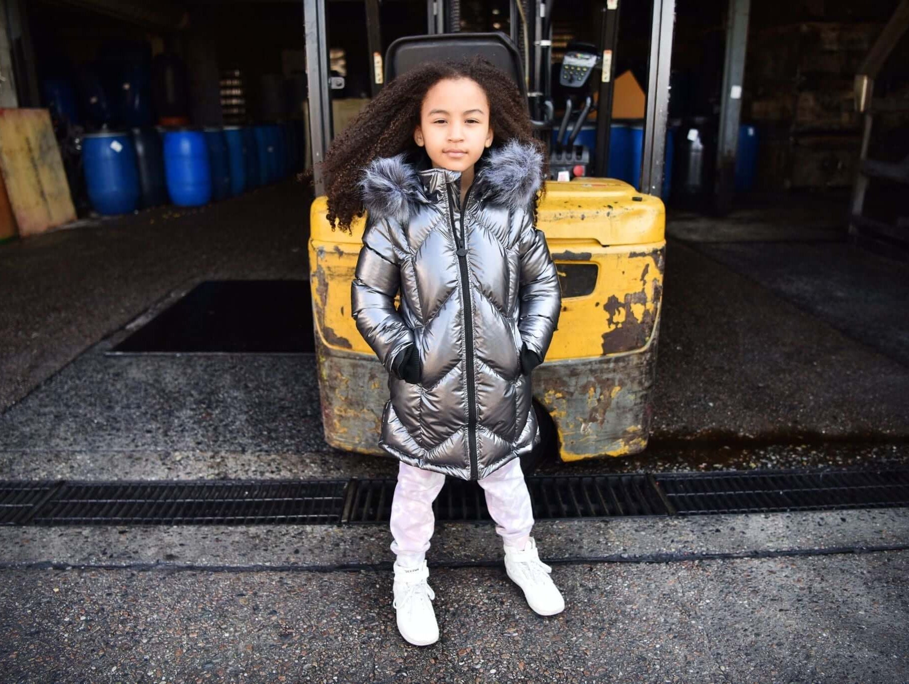 Stylish girl in a metallic down coat, exuding winter vibes while showcasing trendy kids' outerwear from Appaman.