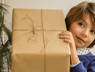Stylish child holding a wrapped gift, embodying modern holiday cheer and thoughtful non-toy gift ideas for kids.