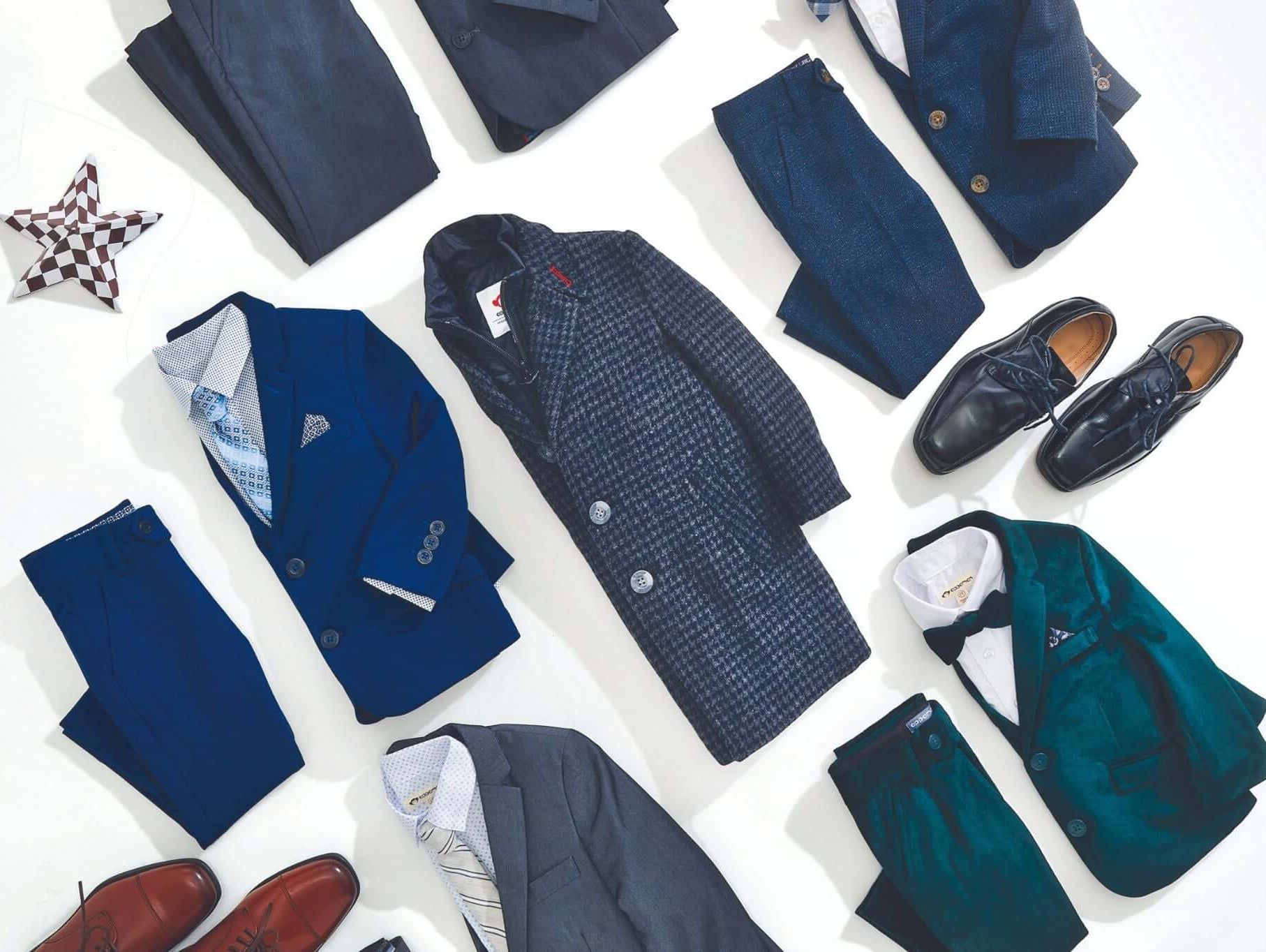 Stylish holiday outfits for boys featuring suits, coats, and shoes laid out for festive occasions.