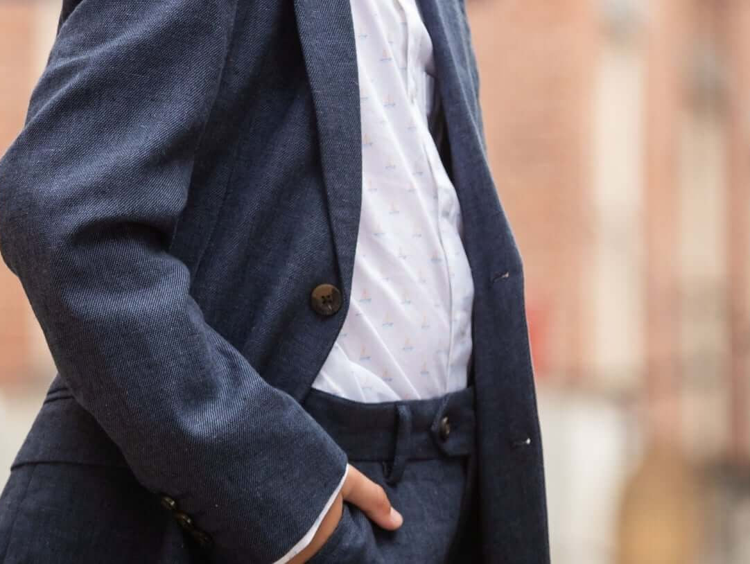 Trendy navy suit in a stylish urban setting; perfect for modern kids' occasions. Discover how to dress kids up confidently!