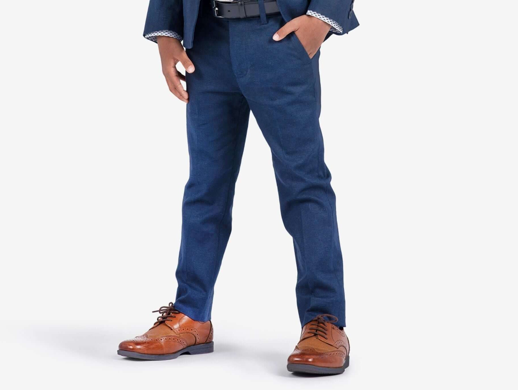 Stylish boy in navy pants paired with classic brown shoes, showcasing modern kids fashion and thoughtful styling tips.