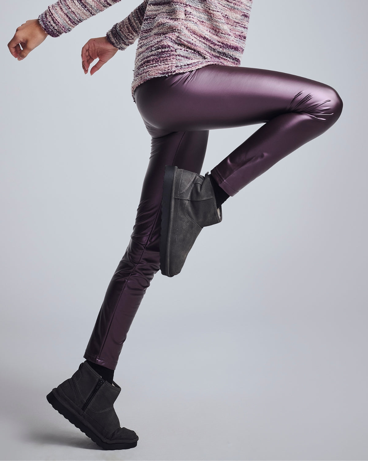 Girl showing off stylish Girls' Leggings in purple with a playful pose and black boots.