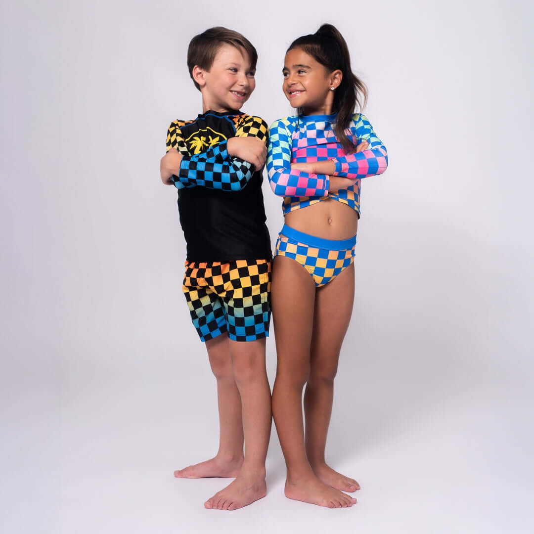 Kids showing off vibrant Appaman swimwear with fun checkered patterns—perfect for splashing into summer adventures!
