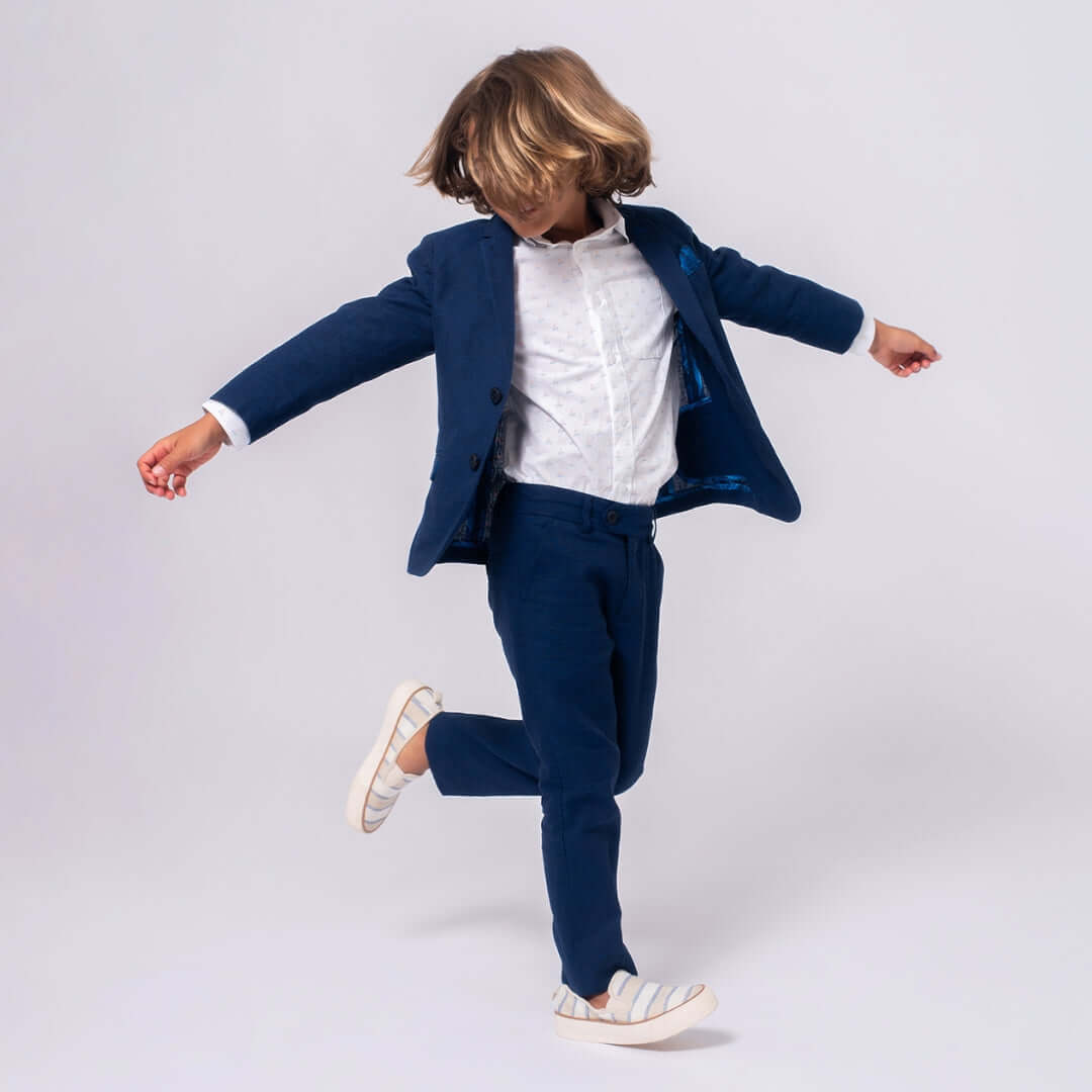 Stylish boy twirling in a navy linen suit from Appaman, ready for summer fun and special occasions.