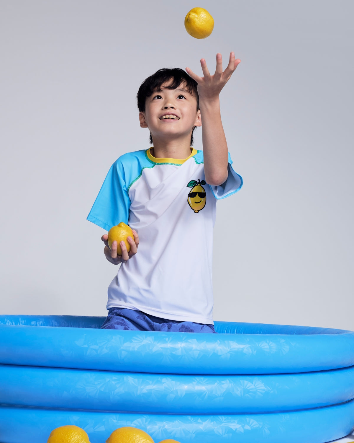 Boys' Rash Guards & Swim Shirts: Smiling boy in colorful checkered swim shirt and shorts, showcasing comfort and style.