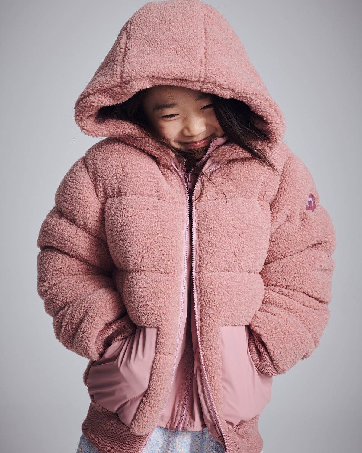 Stylish girl in a shiny purple puffer jacket and black beanie—perfect for cozy winter adventures!