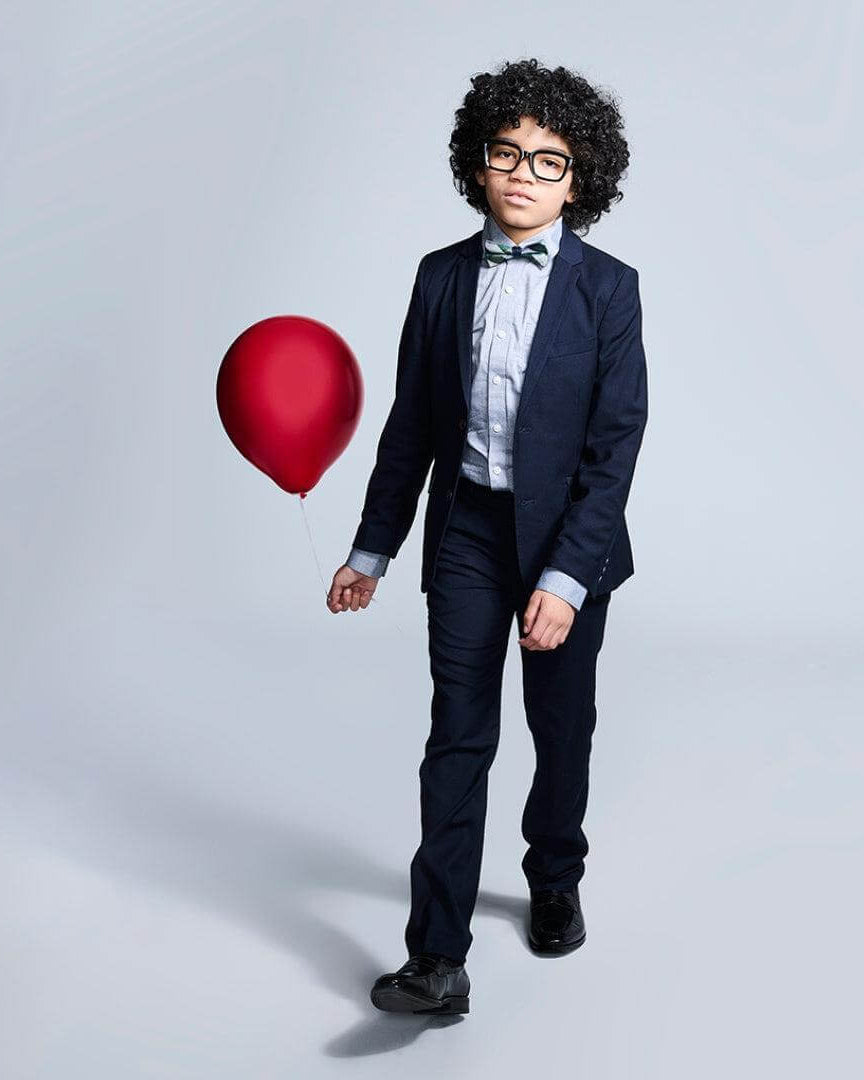 Boys' Navy Suits: Young boy in a navy suit holding a red balloon, showcasing style and elegance for special occasions.