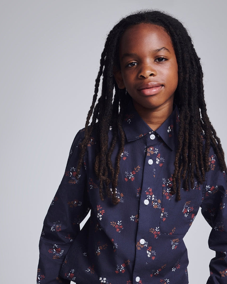 Stylish boy in a white dress shirt with a playful twist, ready for any special occasion in modern kids clothing.