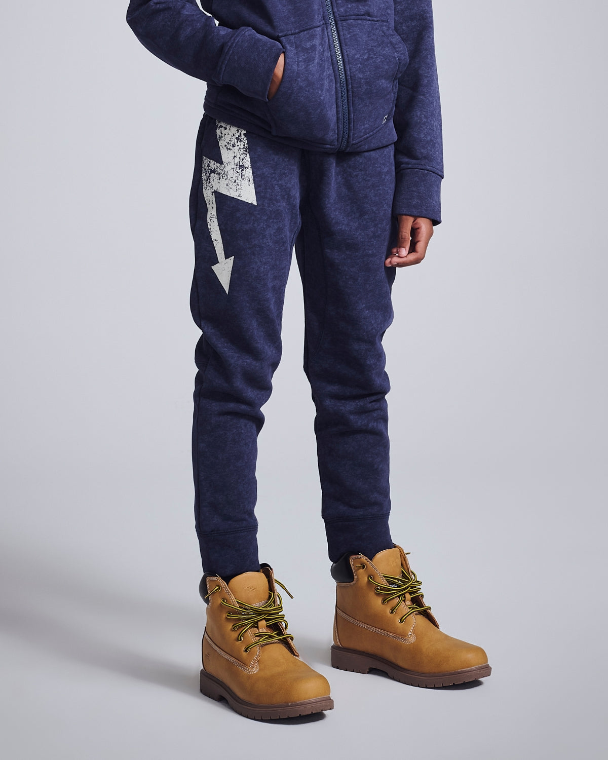 Stylish boy rocking brown sweatpants with lightning detail, perfect for playful adventures and cozy weekends.