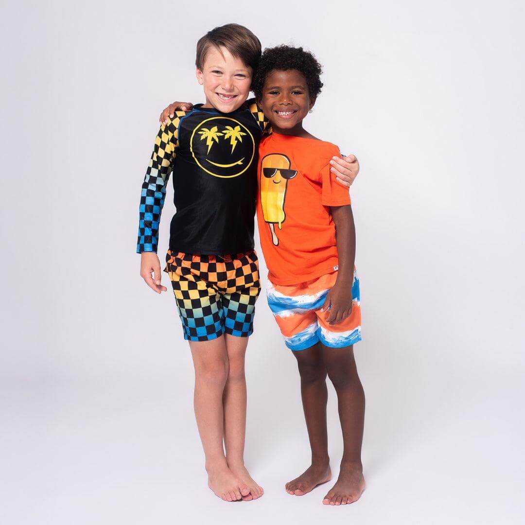 Two boys in vibrant swimsuits, showing off beach-ready style and fun designs—perfect for summer adventures!