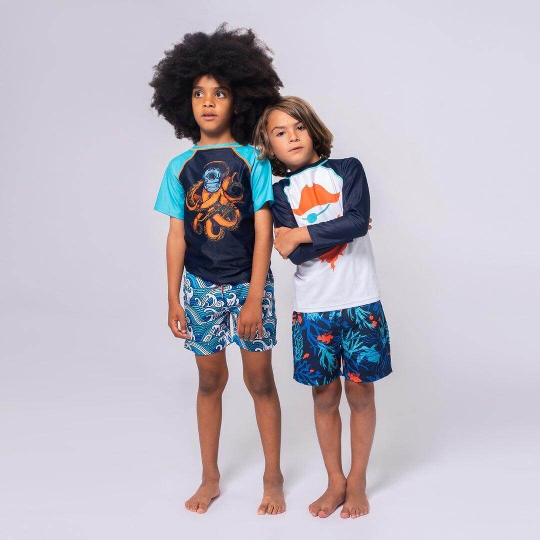 Two boys in vibrant swim cover ups and fun shorts, ready for poolside adventures, blending style and sun safety.