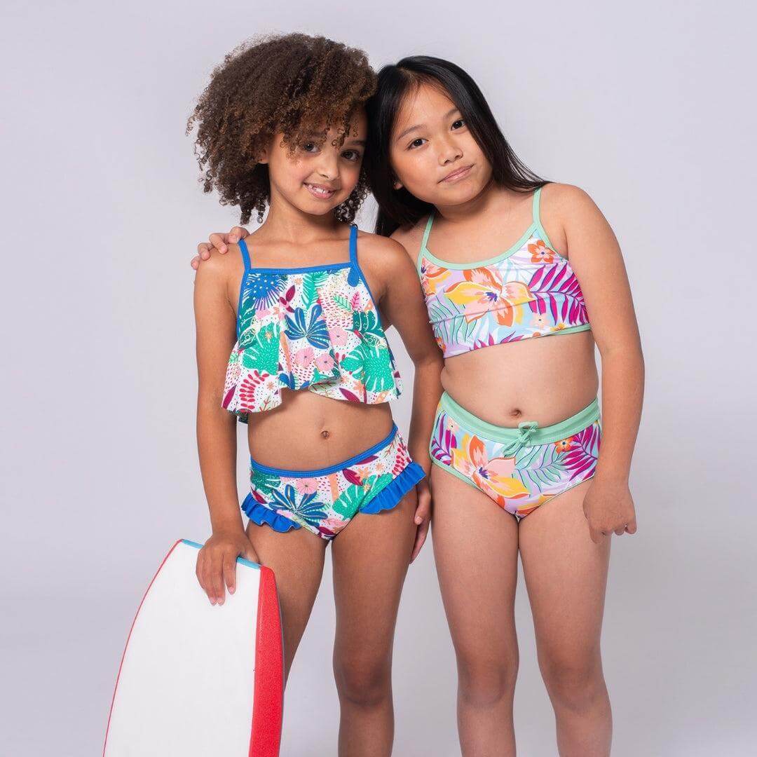 Two stylish girls modeling vibrant floral two-piece swimsuits, perfect for summer fun and beach adventures.
