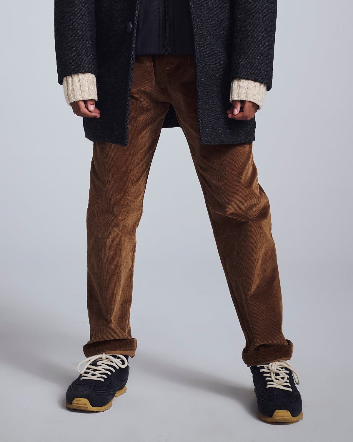 Boys' Chino Pants displayed on a model wearing a stylish coat and sneakers for a trendy look.
