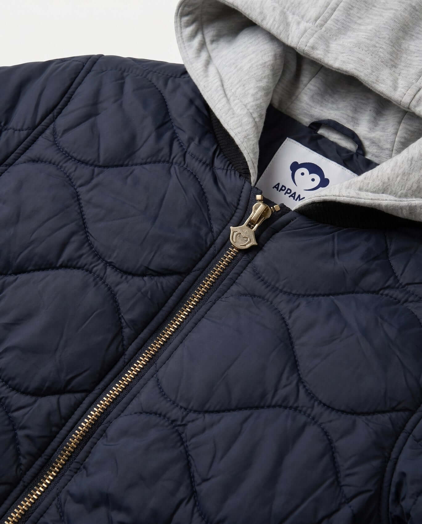 Navy quilted jacket with gold zipper and gray hood, featuring a brand label.