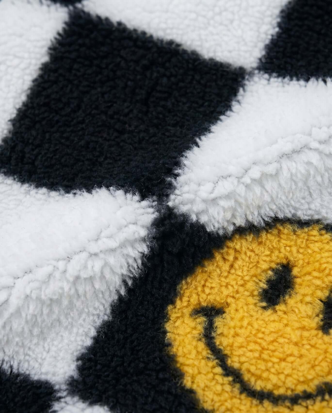 Close-up of a textured fabric with a smiley face design.