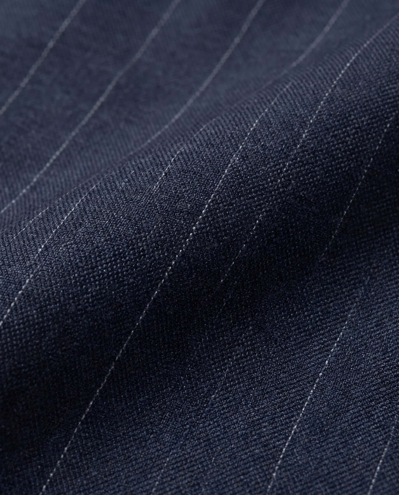 Close-up of dark blue fabric with subtle pinstripes