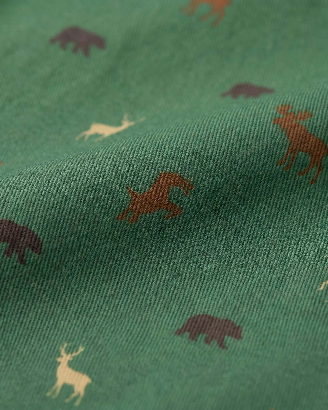 Green fabric with brown and beige animal prints including bears, deer, and moose.