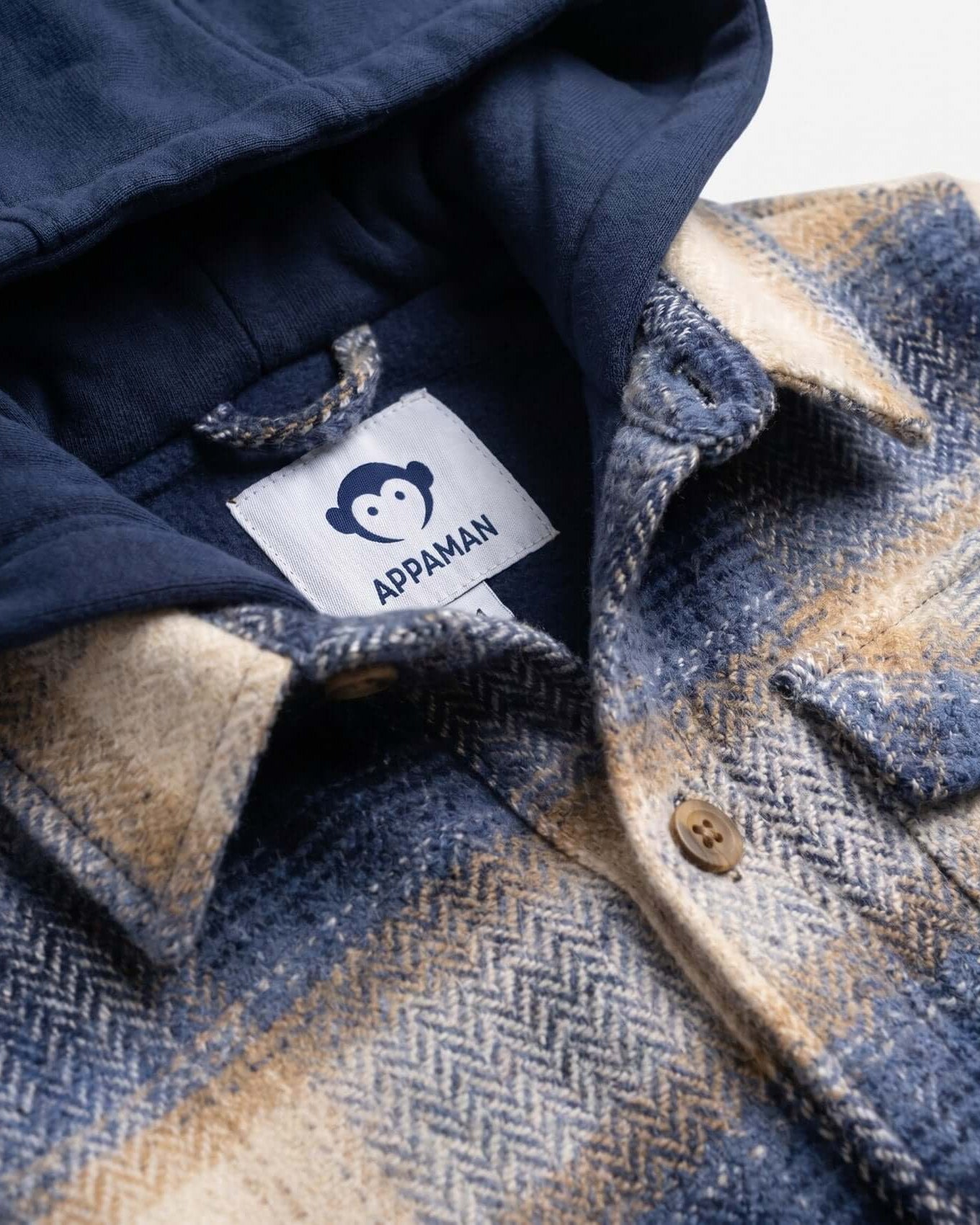 Close-up of a navy and plaid jacket with Appaman label