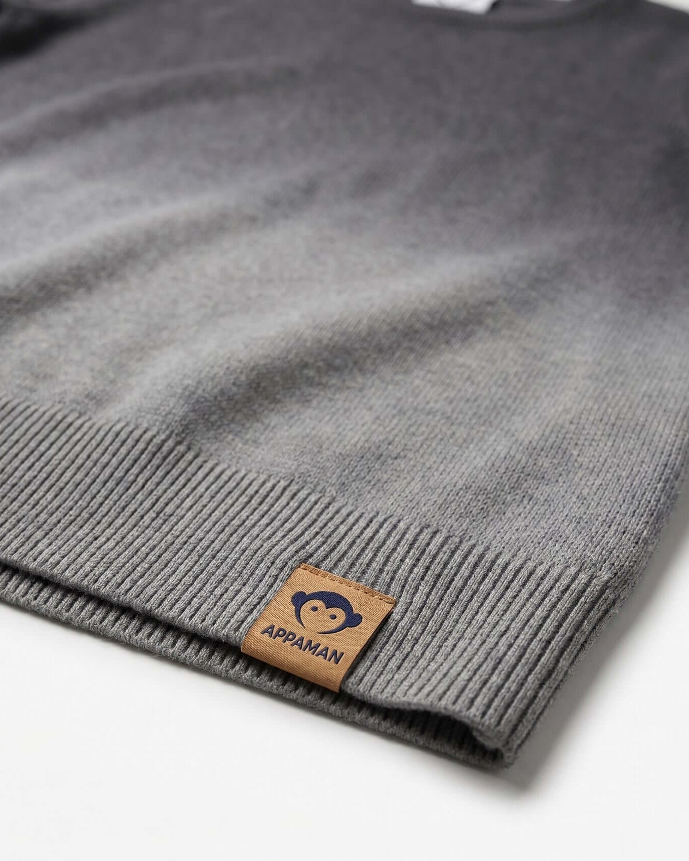 Gray sweater with a brown label on a white background