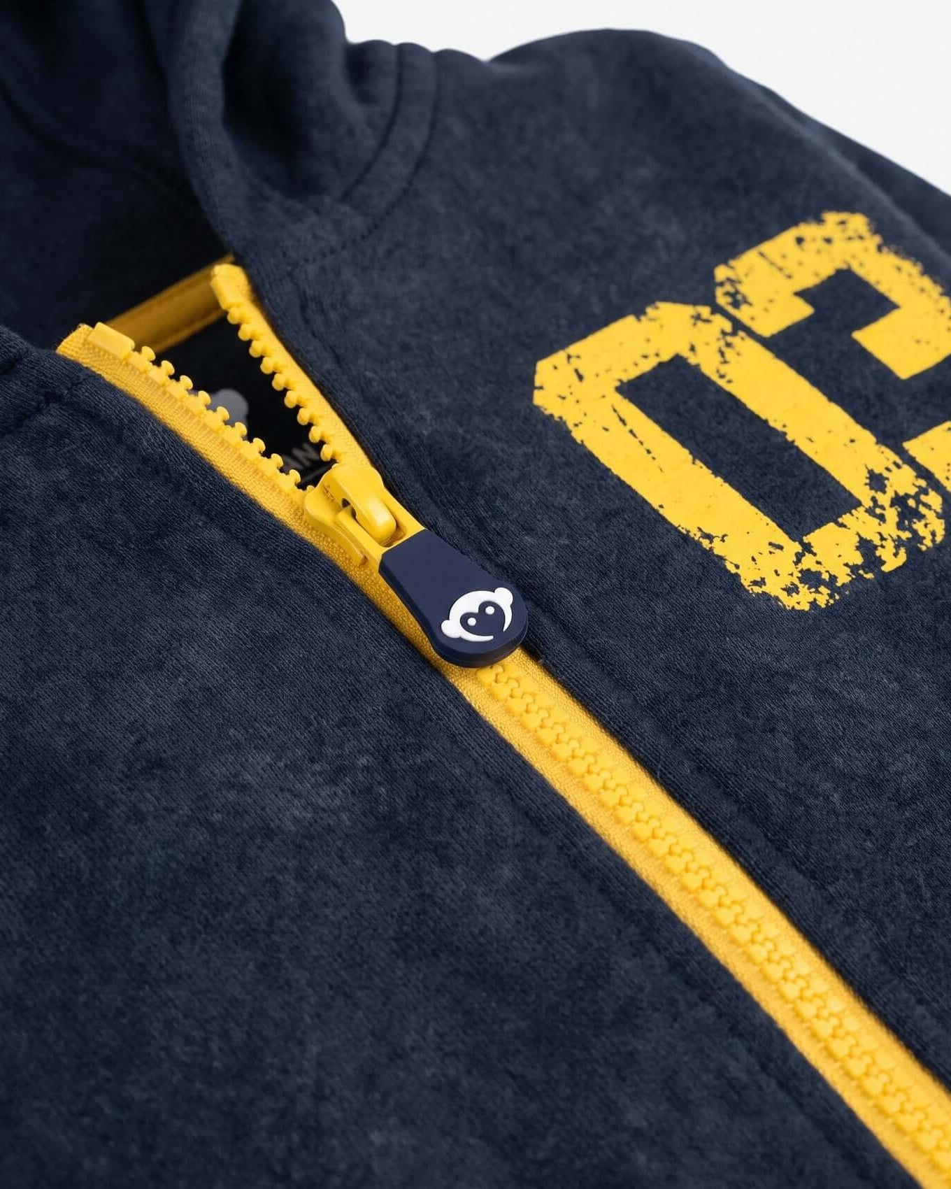 Navy blue hoodie with yellow zipper and logo on a white background