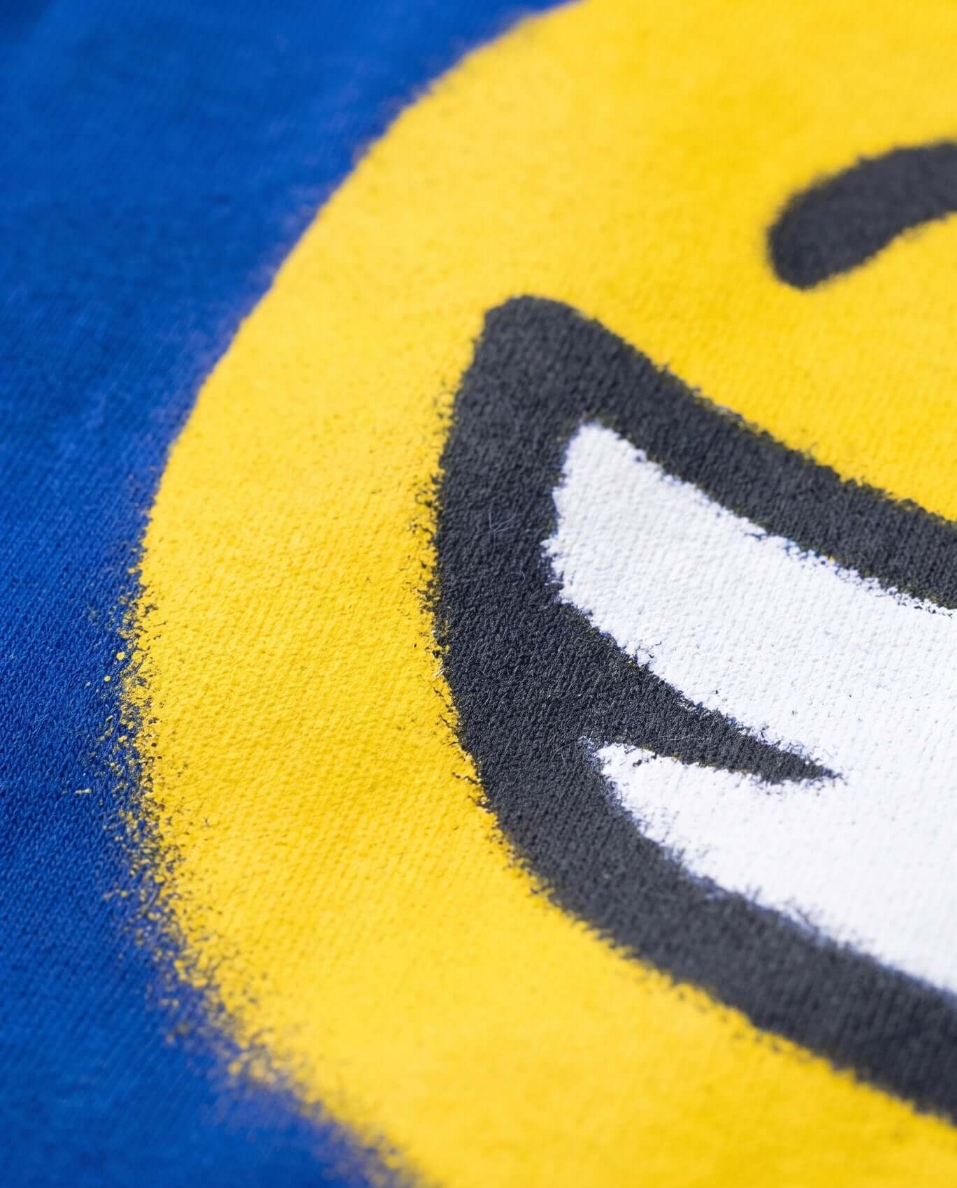 Close-up of a smiley face design on fabric with blue and yellow background