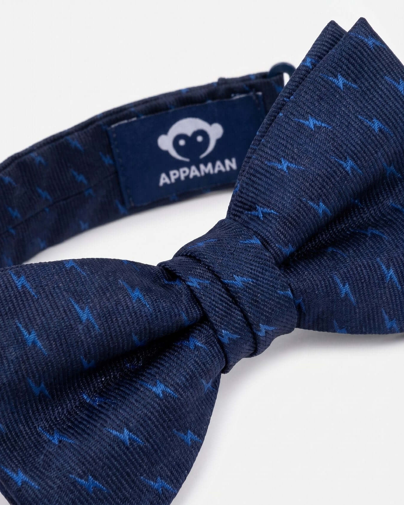 Navy blue bow tie with subtle pattern on a white background, featuring Appaman brand label.