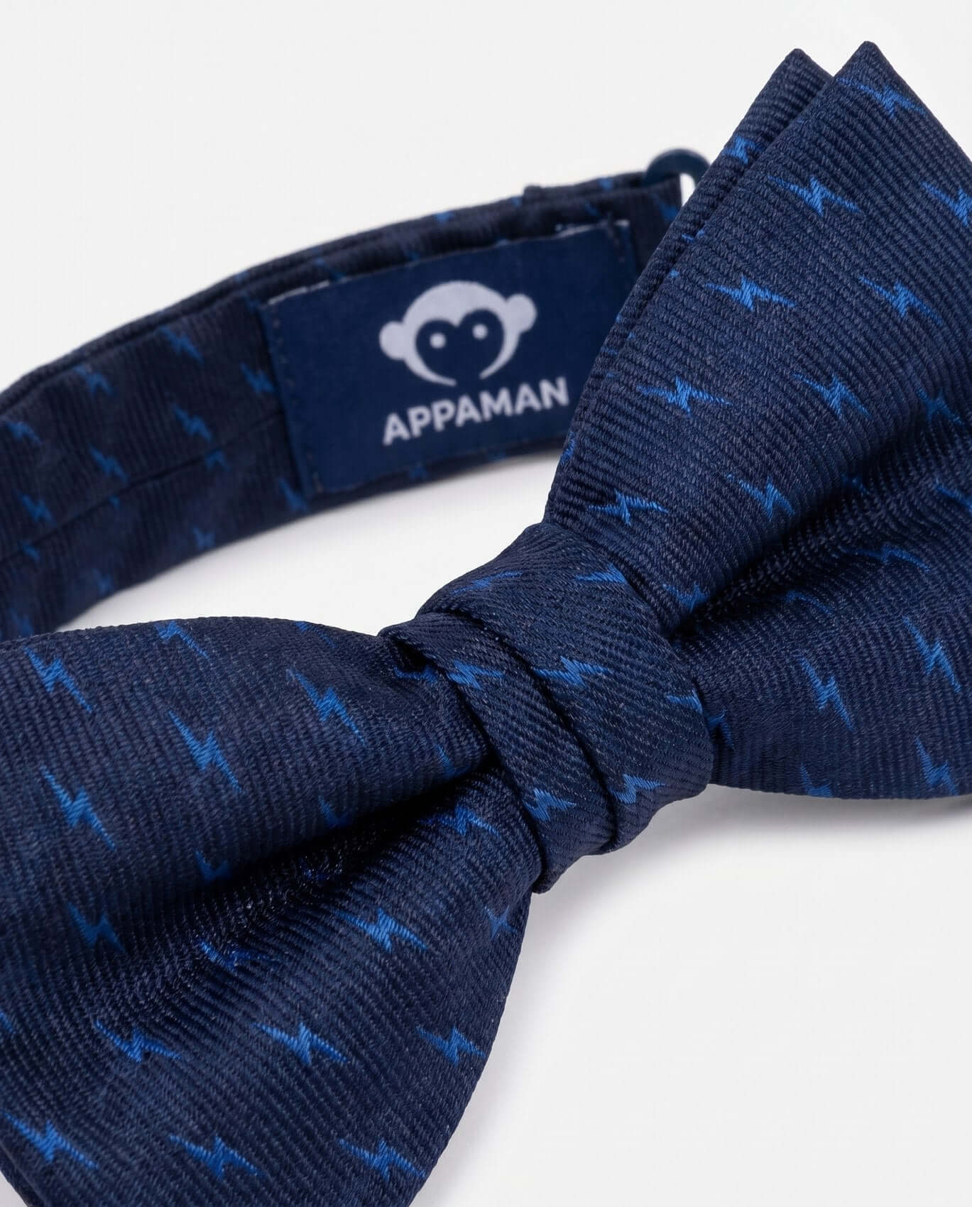 Navy blue bow tie with subtle pattern on a white background, featuring Appaman brand label.