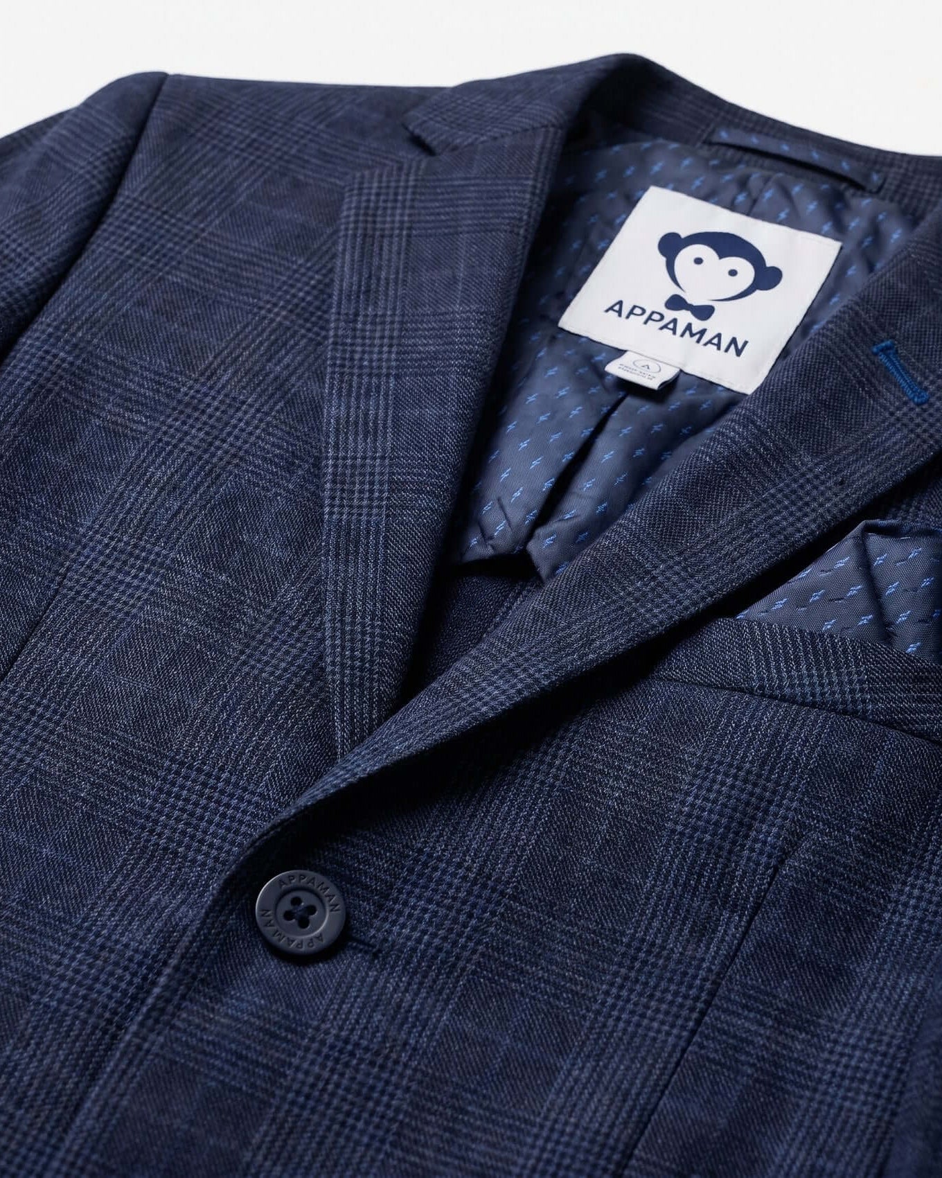 Navy checkered jacket with Appaman label on a matching fabric background