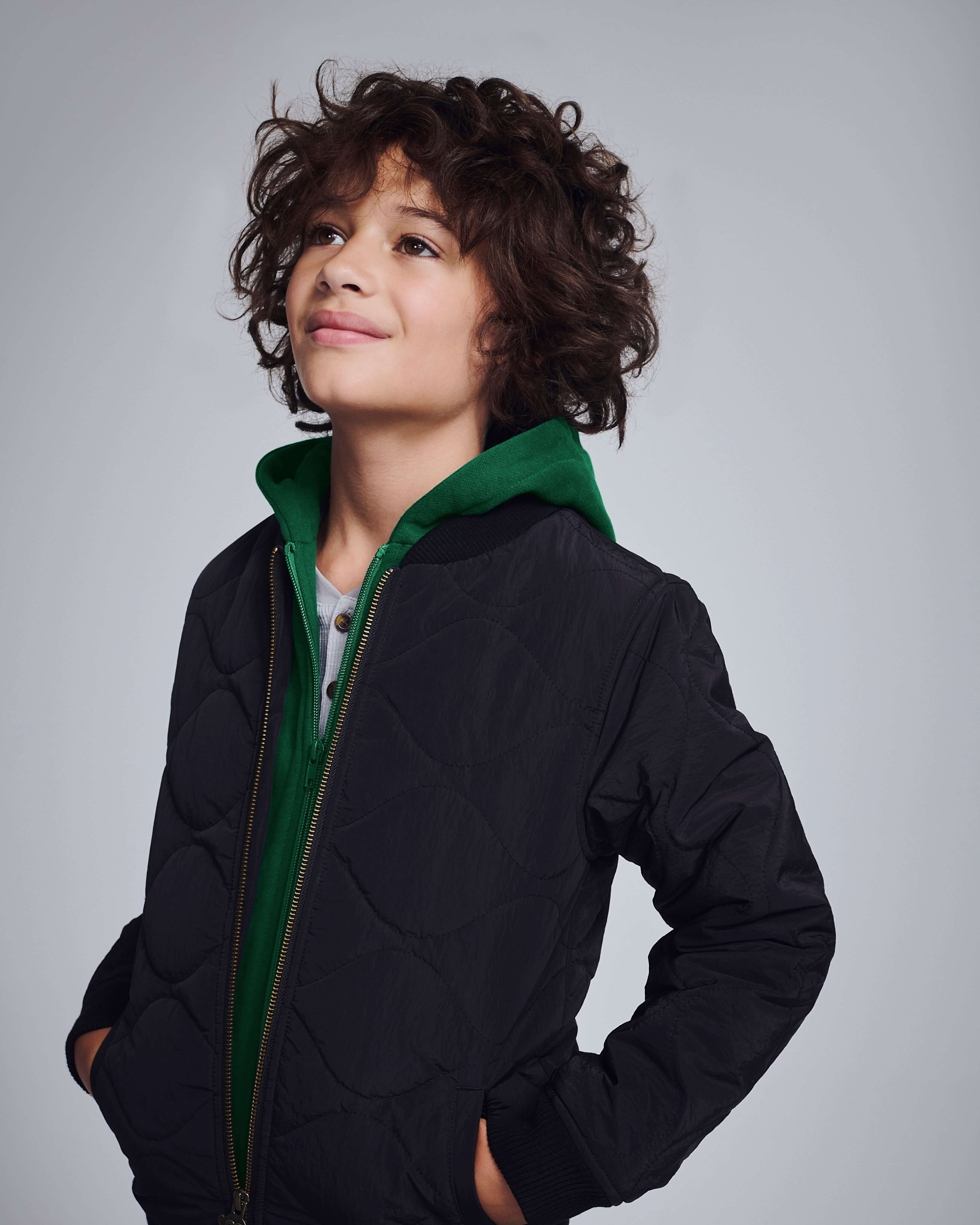 Black BX Bomber jacket on a child with a green hood, showcasing a stylish and functional look.