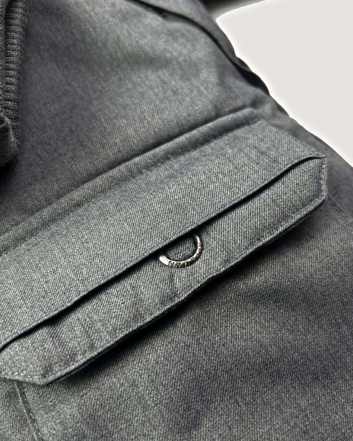 Close-up of the Grey Denali Down Coat showing pocket detail and rugged fabric texture.