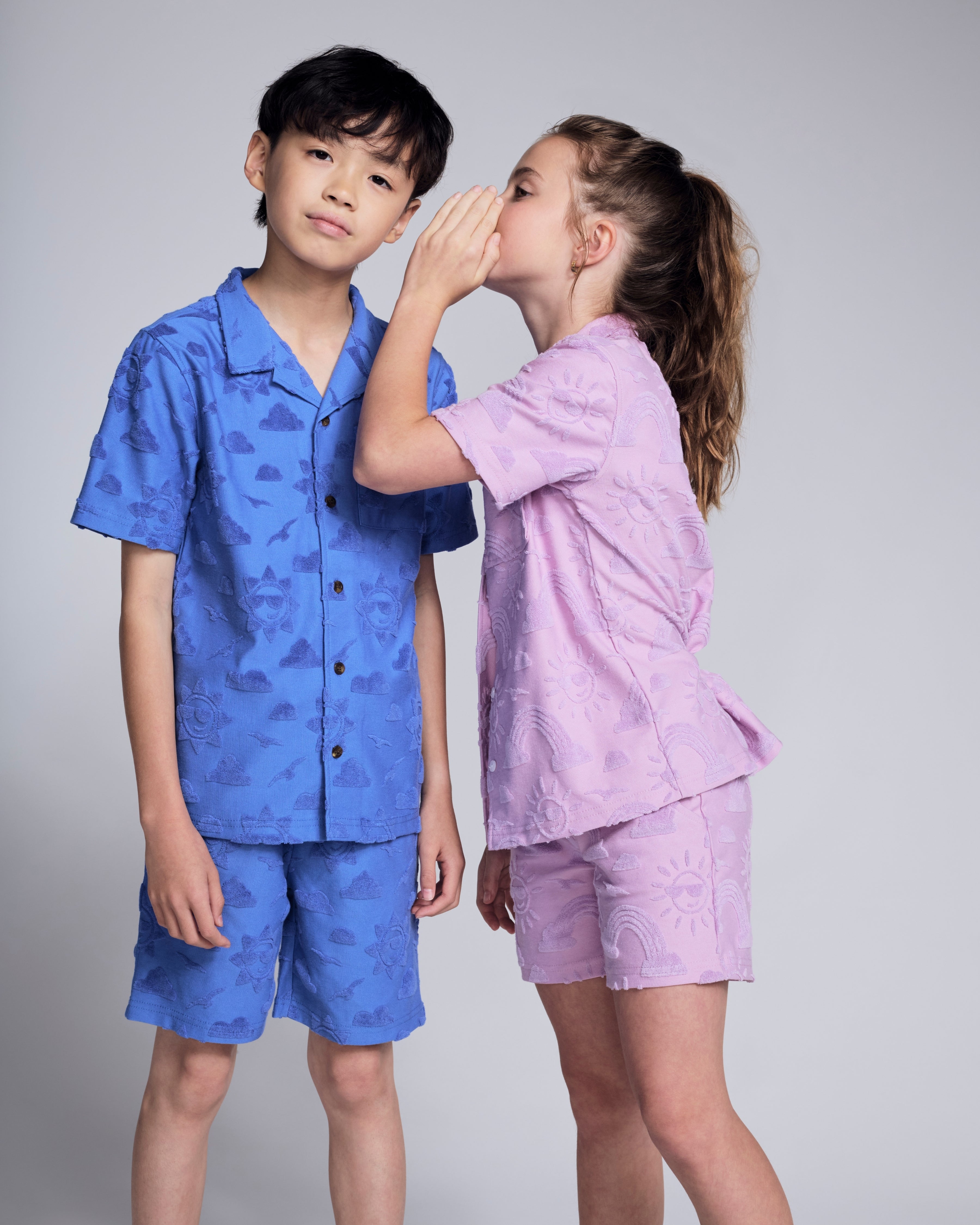 Two kids wearing Cobalt Blue Terry Resort Shirt and pink shorts, showcasing summer fashion and relaxed style.