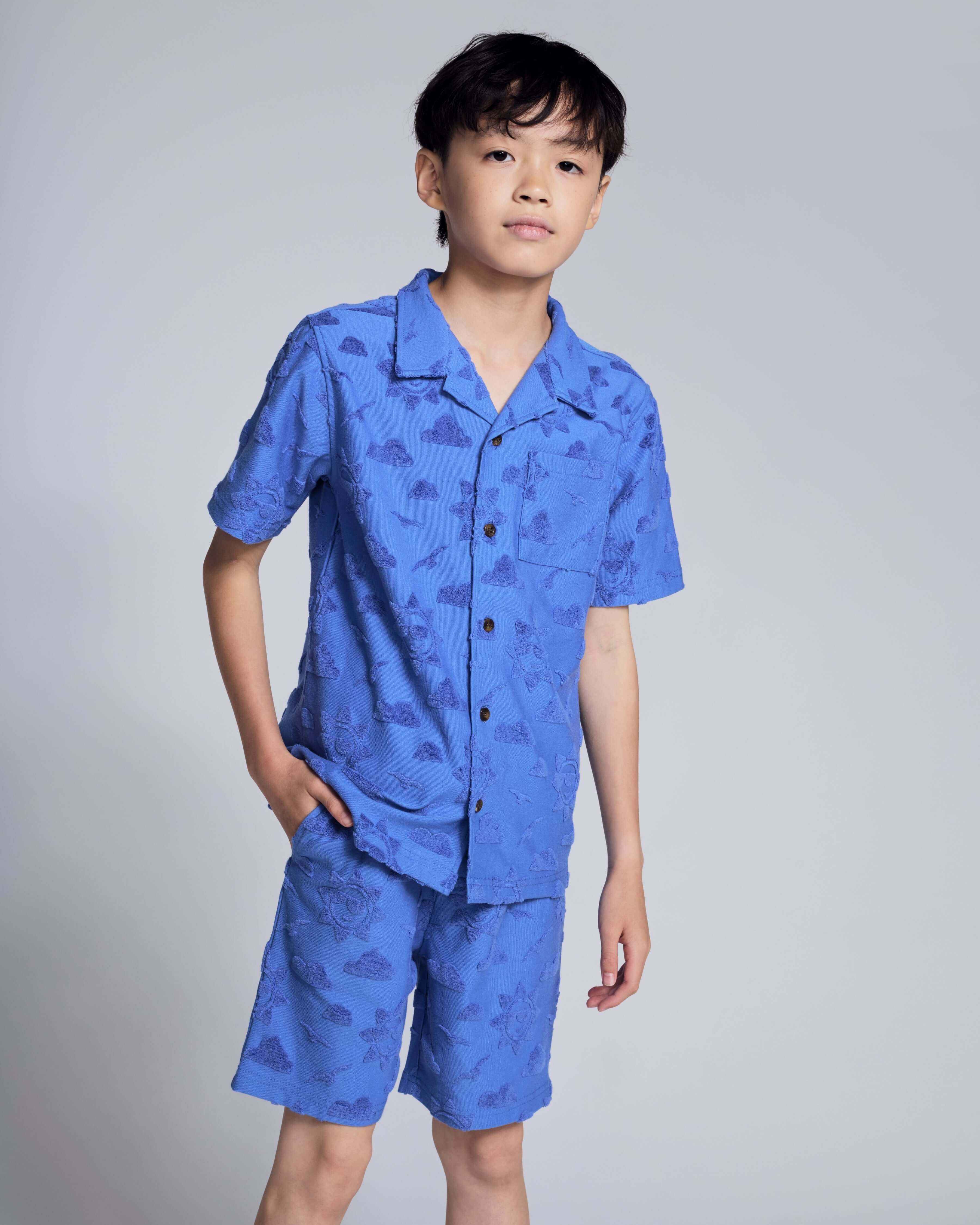 Cobalt Blue Terry Resort Short paired with matching shirt, featuring a playful sun and clouds print for kids.