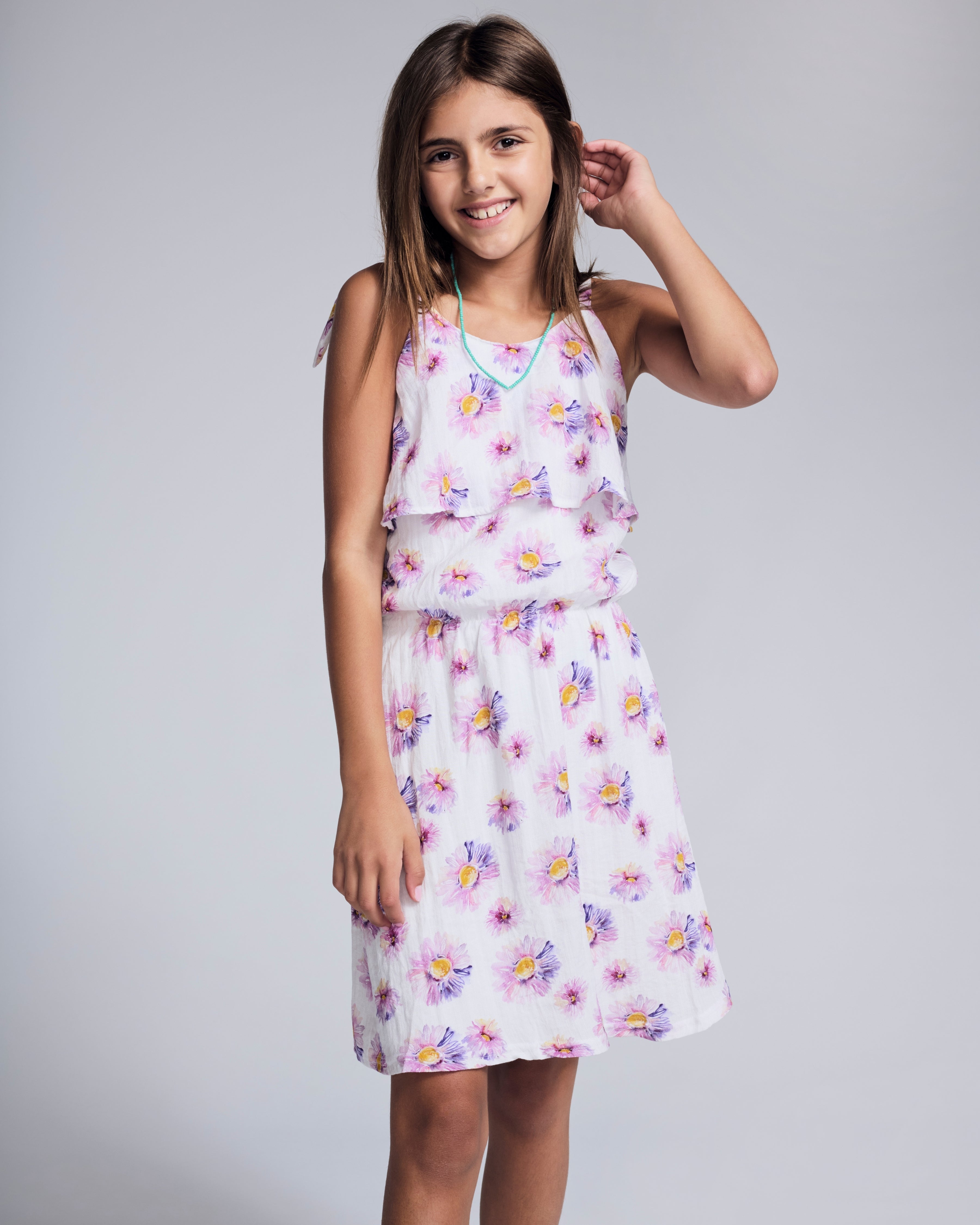 Girl wearing the Daisies Leah Layered Dress with floral print and layered details, perfect for sunny days.