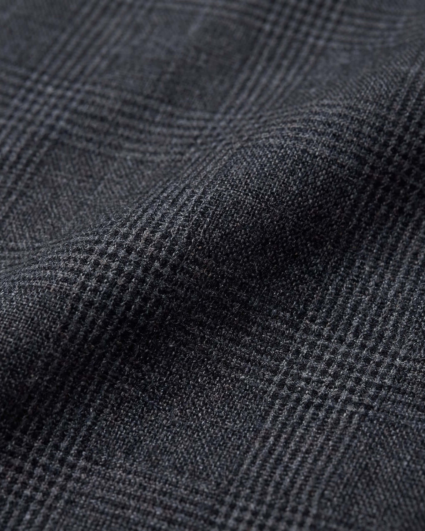 Close-up of dark gray fabric with a subtle check pattern