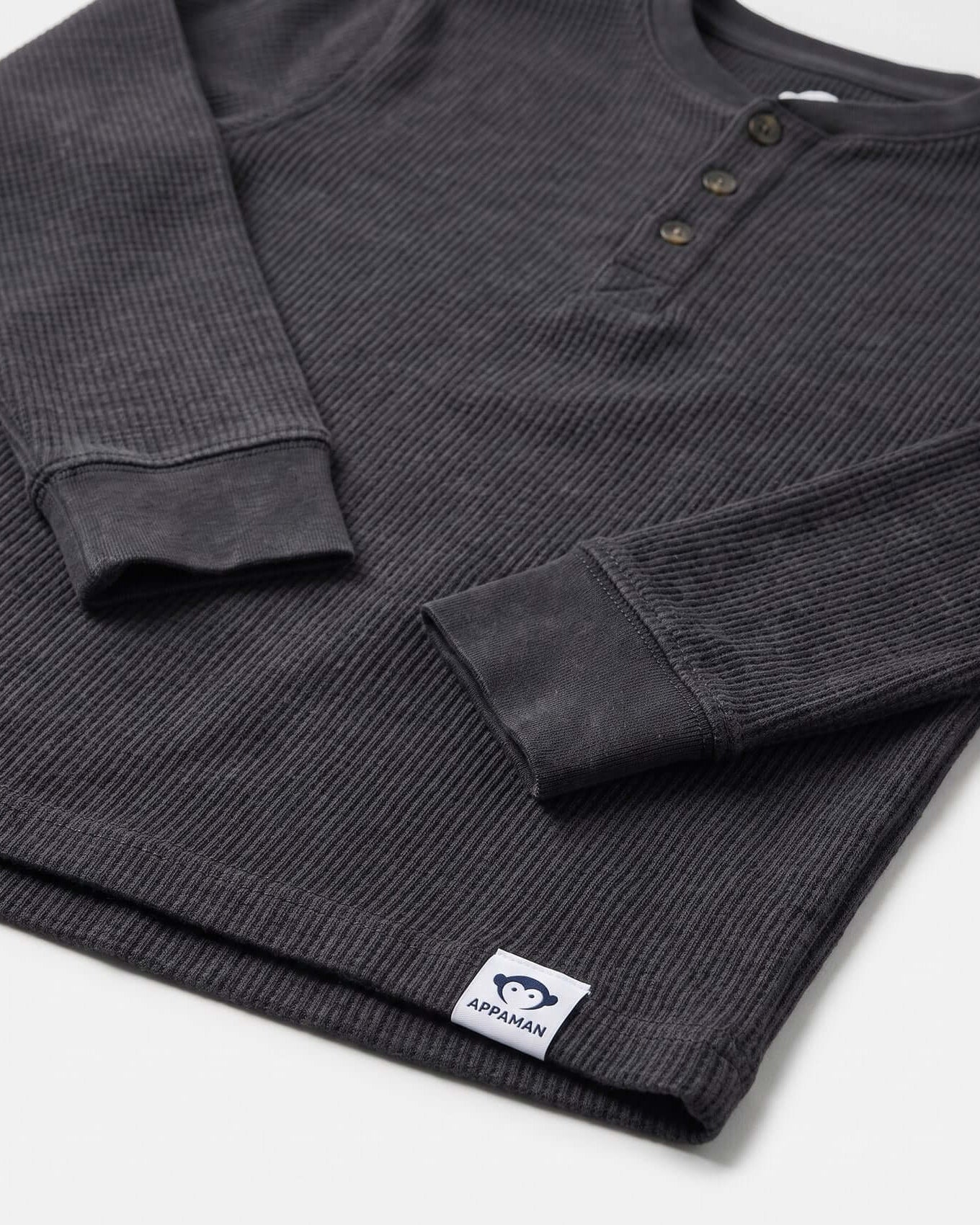 Dark gray ribbed long-sleeve shirt with a brand label on a white background
