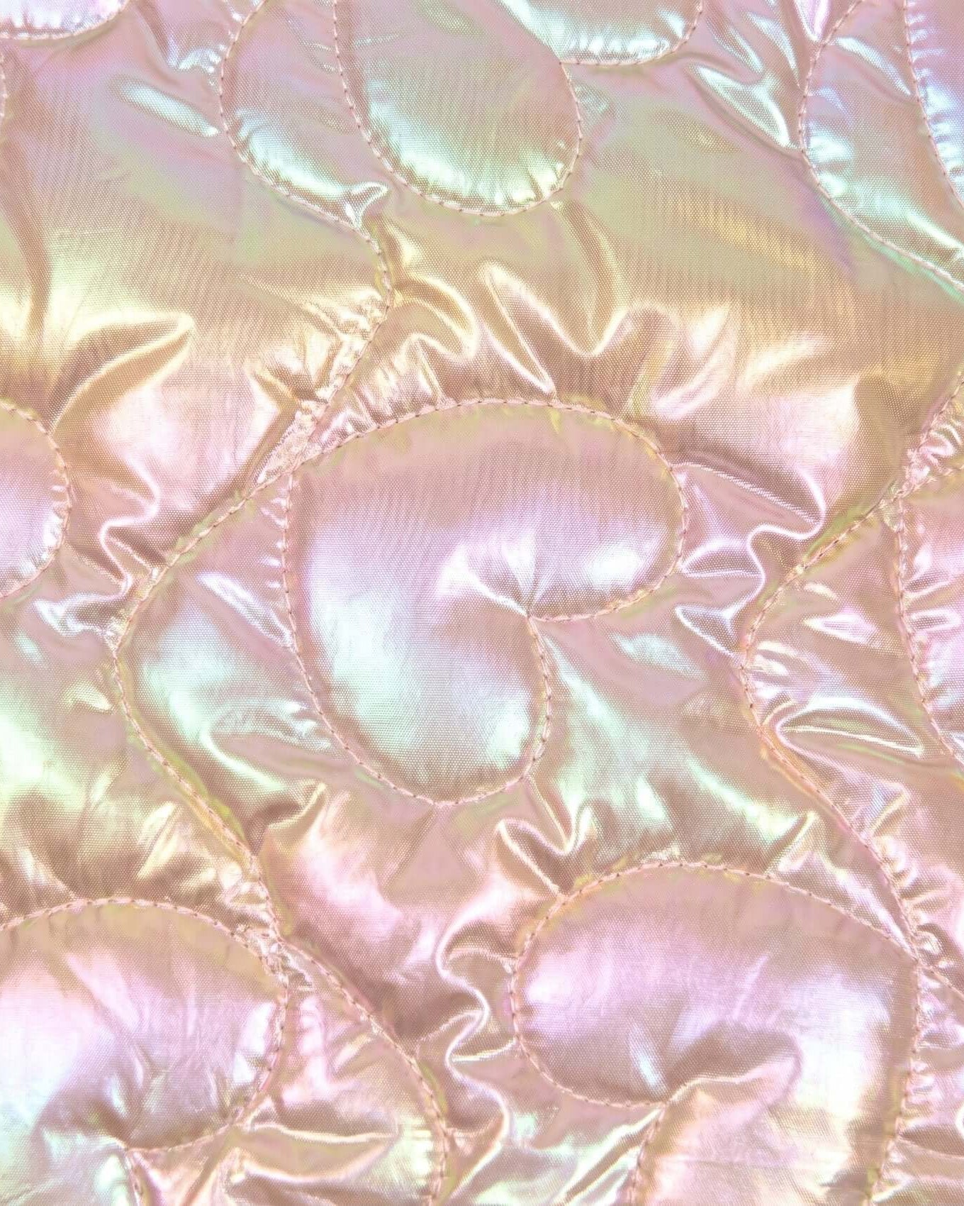 Close-up of iridescent quilted fabric with circular patterns