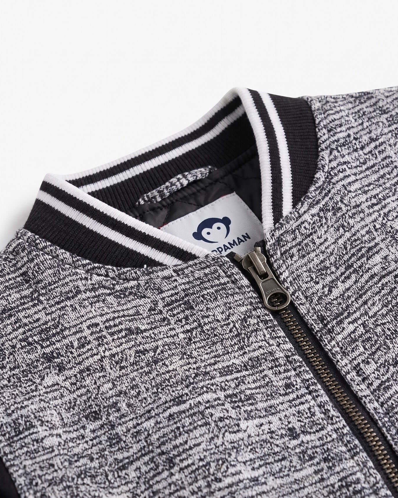 Close-up of a gray and black jacket with a brand logo on a white background