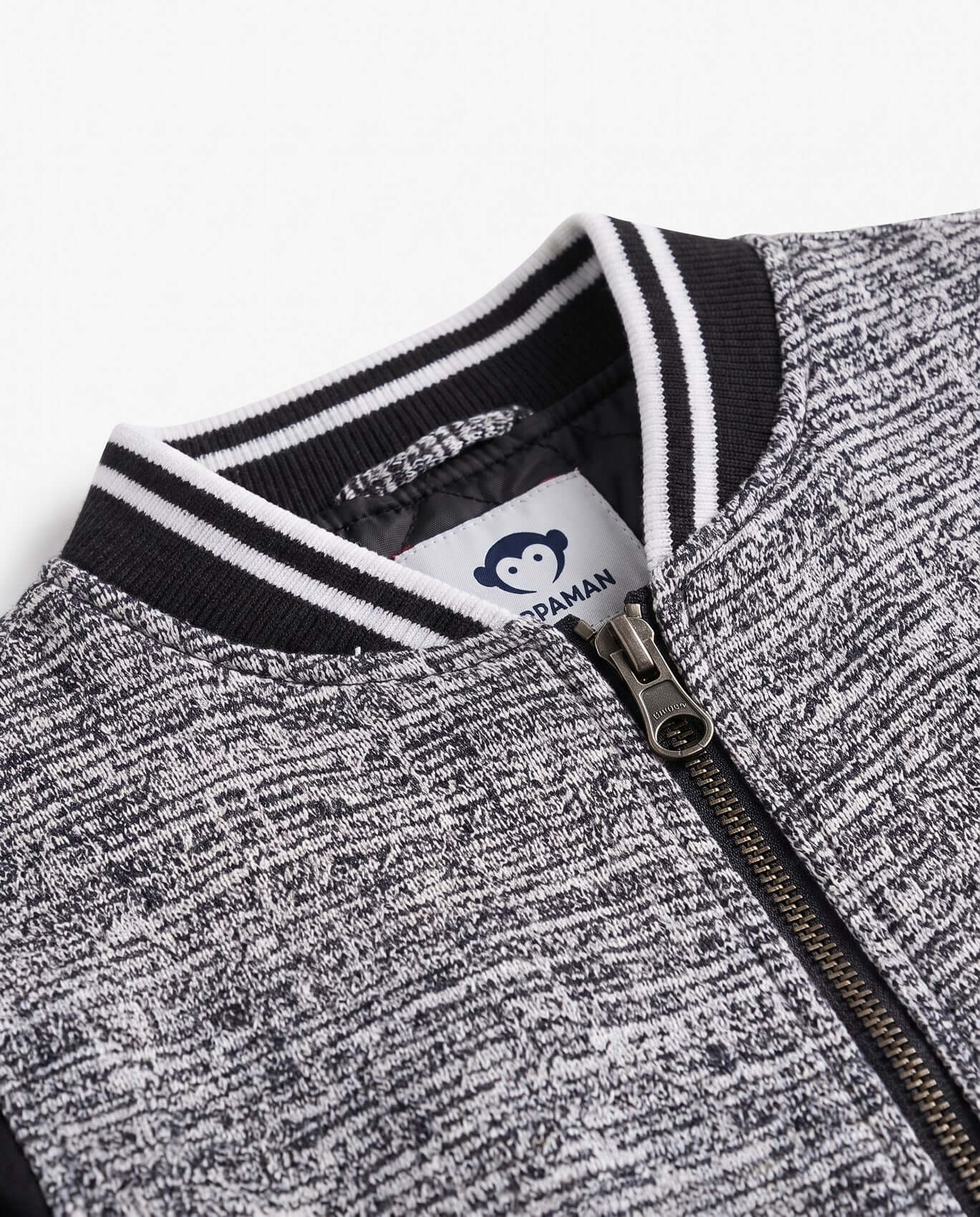 Close-up of a gray and black jacket with a brand logo on a white background