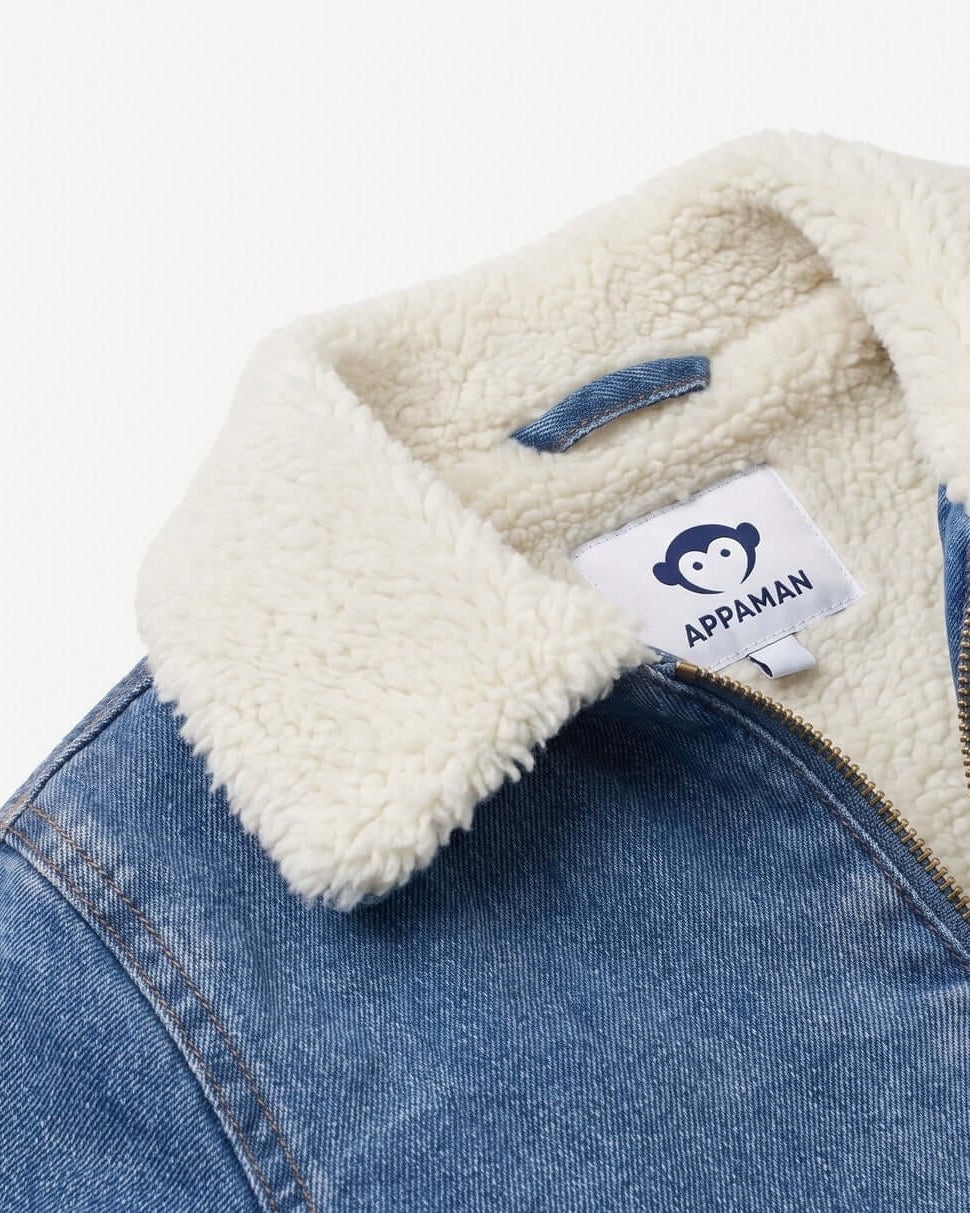 Close-up of a denim jacket with a white sherpa lining and Appaman label.