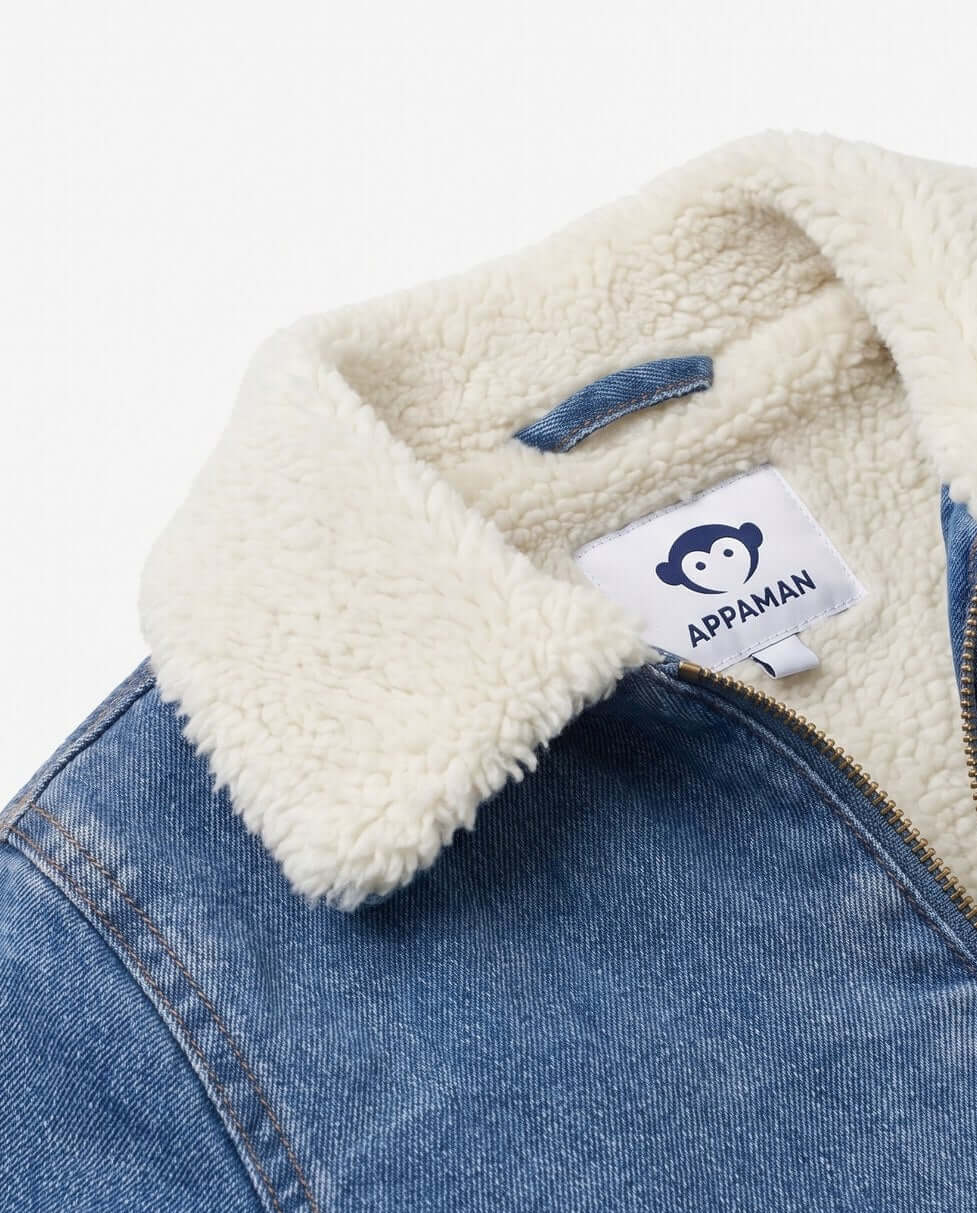 Close-up of a denim jacket with a white sherpa lining and Appaman label.