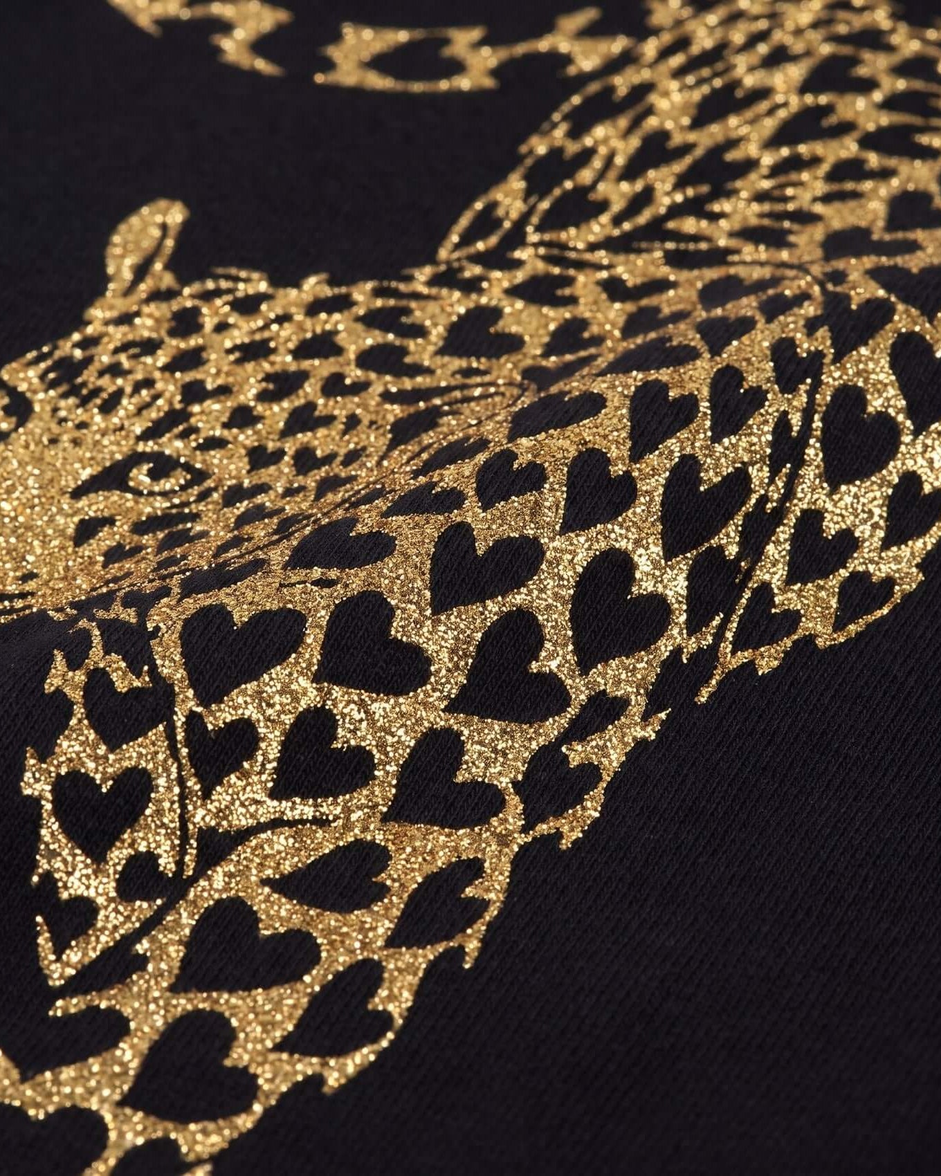 Close-up of a leopard pattern with black hearts on a dark background
