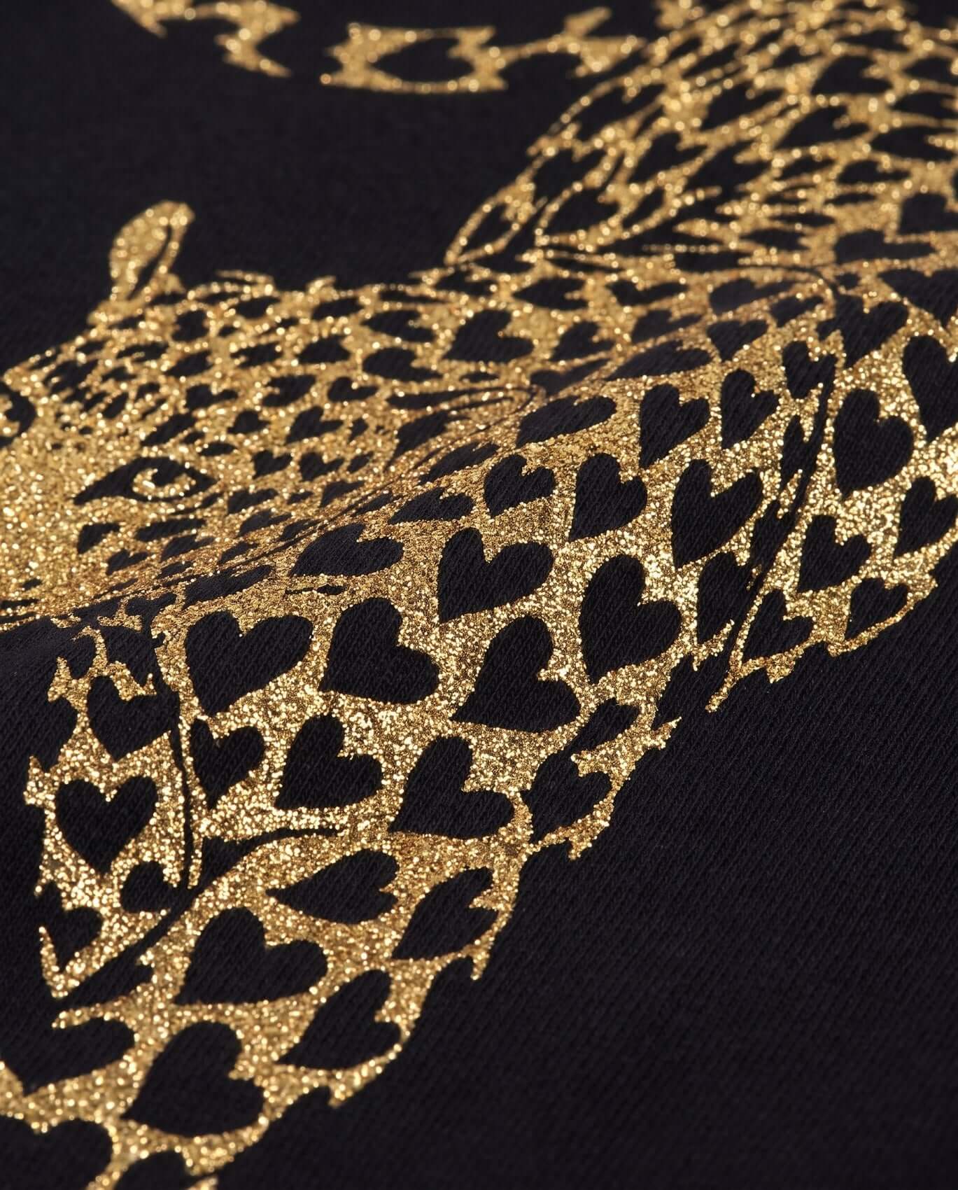 Close-up of a leopard pattern with black hearts on a dark background