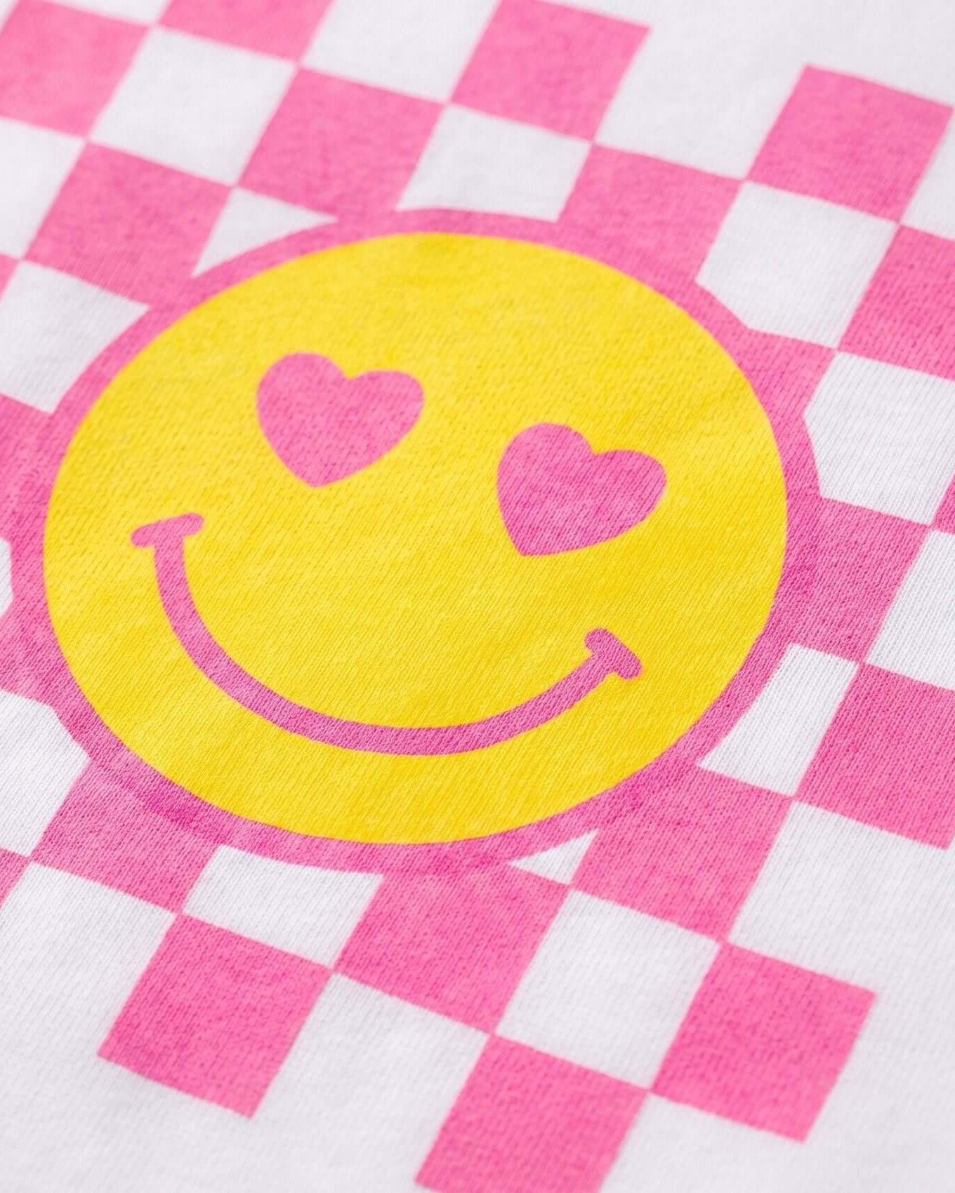 Yellow smiley face with pink hearts on a pink and white checkered background